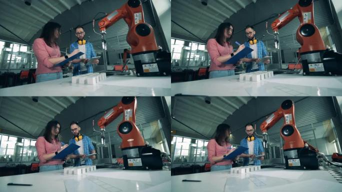 两名工程师正在记录一个机器人的实验
