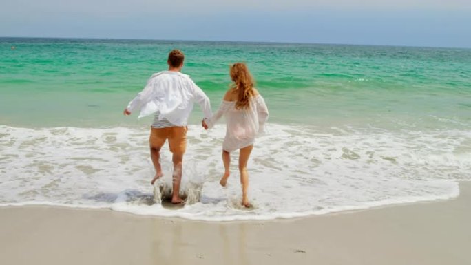 在海滩上奔跑的高加索夫妇的后视图4k