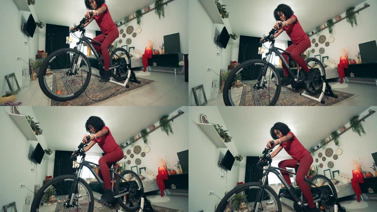 一位非裔美国女士正在使用Exercycle在家进行训练。在家运动，在家健身。