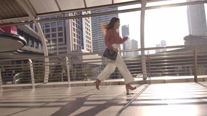 慢动作亚洲女商人在城市跑步