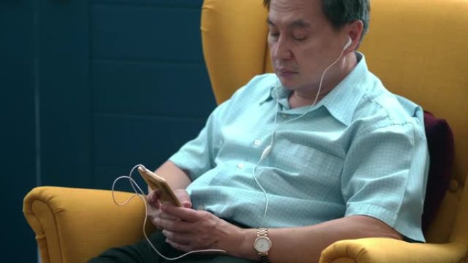 亚洲男子收听播客手机上听音乐外国人男人听