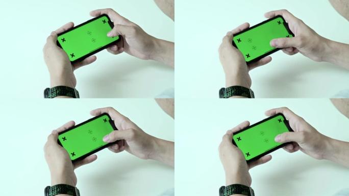 男人在家使用、滚动和查看带色度键的智能手机绿屏