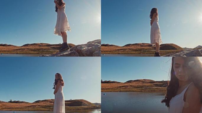 美丽的年轻女子走在阳光明媚的岩石上，享受阳光明媚的湖景，奥地利失败者山