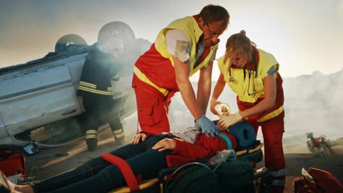 在车祸交通事故现场: 医护人员挽救了躺在担架上的女性受害者的生命。他们使用氧气面罩，进行心肺复苏/C