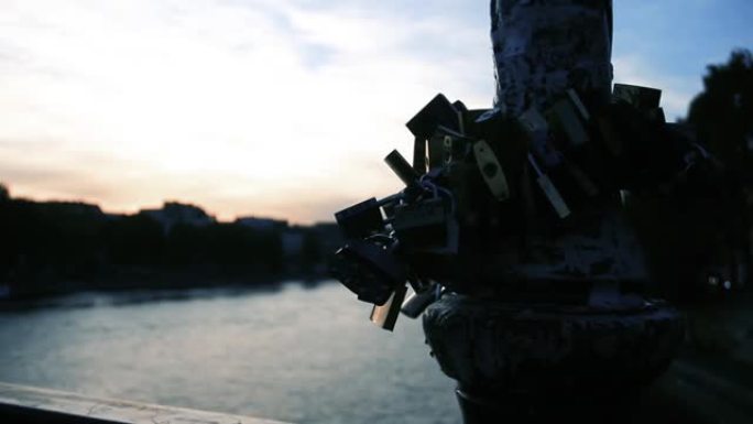 在美丽的日落时分，在巴黎的一座桥上象征爱情的挂锁。