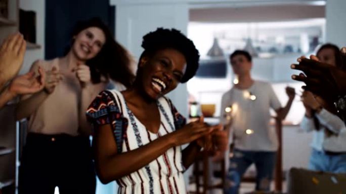 快乐的年轻黑人女大学生与多民族朋友慢动作在令人惊叹的有趣舞会上跳舞。