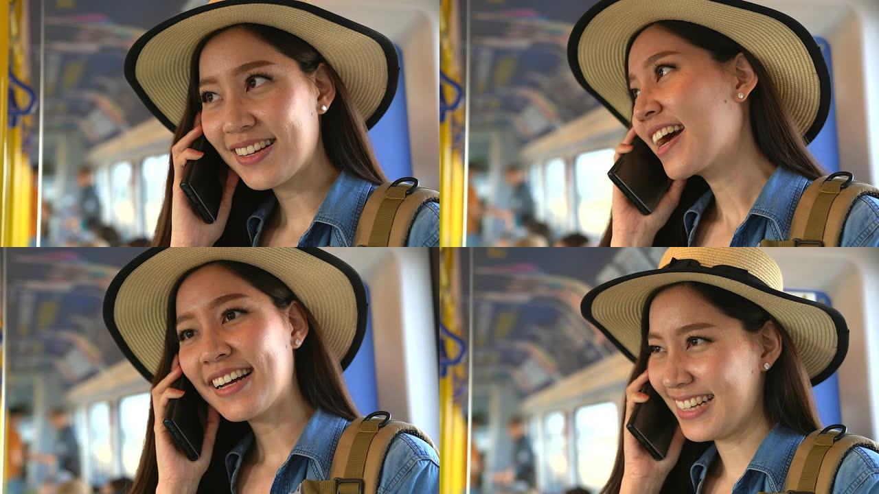 年轻的休闲女子在火车上用智能手机聊天。