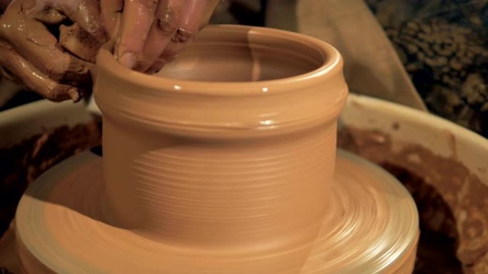 制罐的过程，特写。陶轮上的罐子成型。