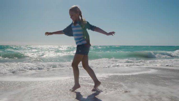 年轻女孩在海滩上的水中行走
