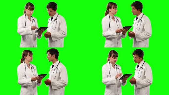 医生讨论和持有绿屏数字平板电脑的侧视图