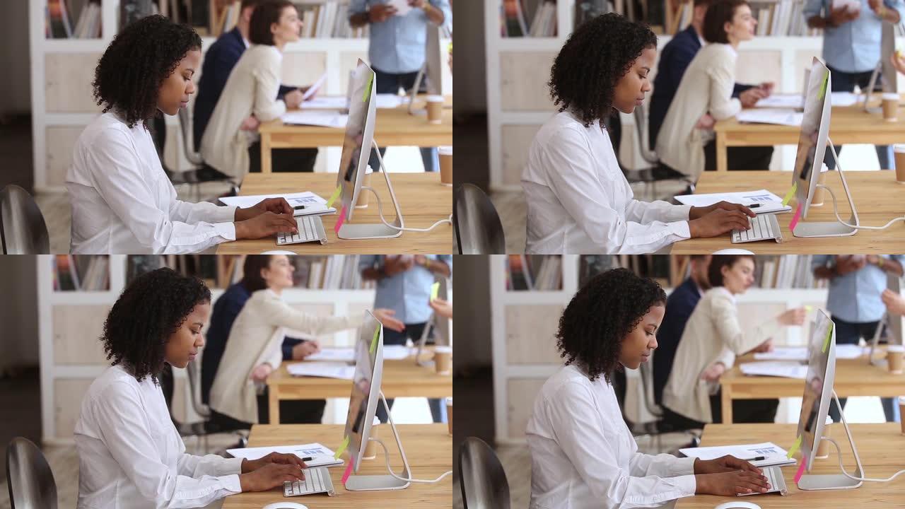 黑人女性员工在键盘上打字，看着pc屏幕