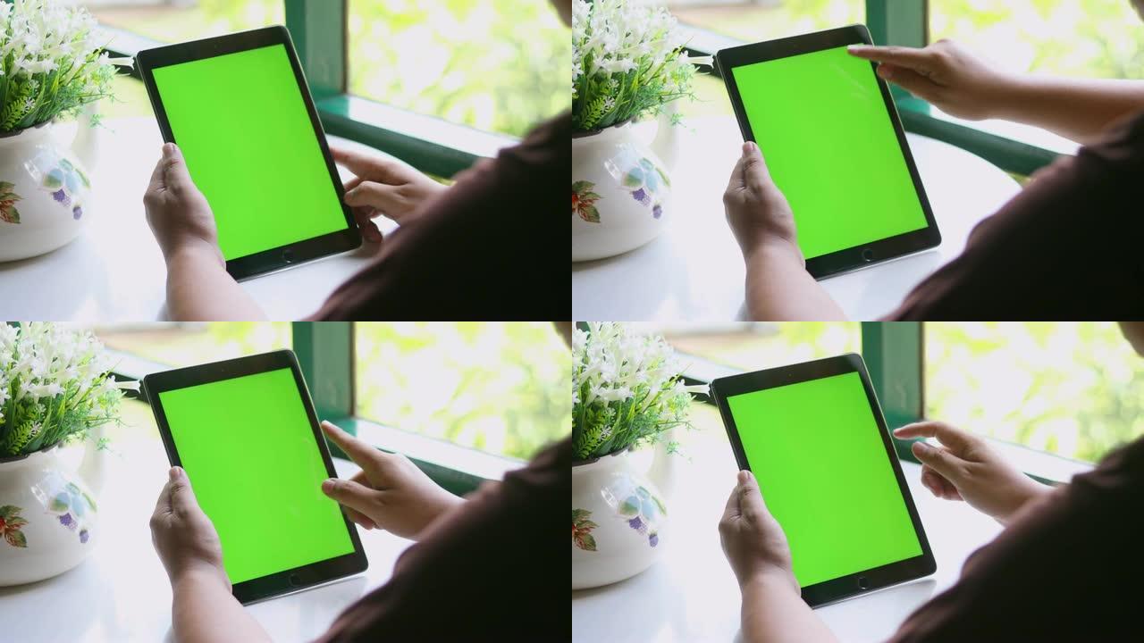 特写女性手持空白平板电脑，绿屏