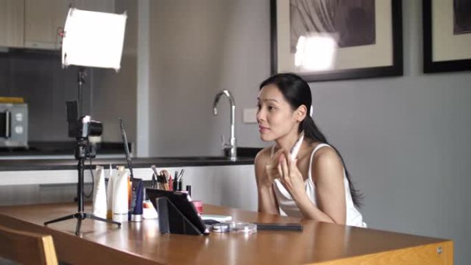 亚洲年轻女子Youtube博客在家里录制带有化妆化妆品的vlog视频，使社交媒体概念成为在线影响者。