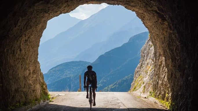 公路自行车手进入山区的岩石隧道