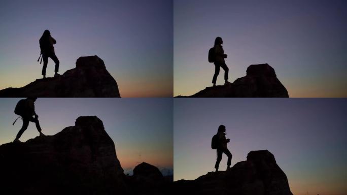 女摄影师在太阳升起前在山顶上拍照