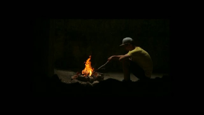 年轻人坐在篝火旁