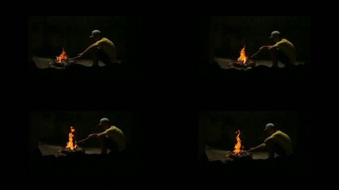 年轻人坐在篝火旁