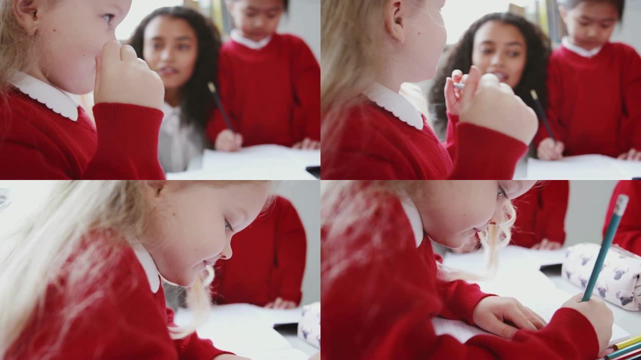 年轻的白人女学生在婴儿学校教室的桌子上画画，特写，侧视图