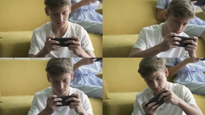 认真的男孩在智能手机上玩视频游戏