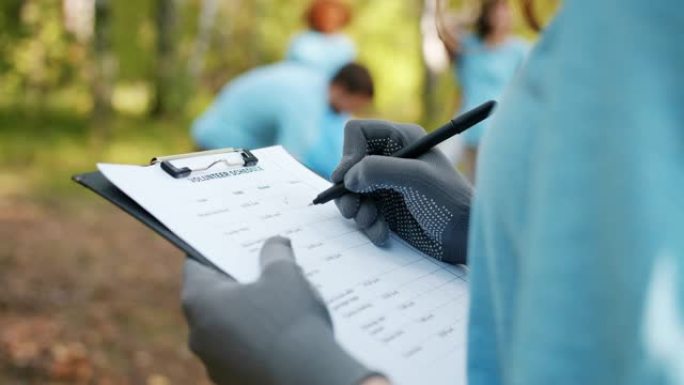 特写女性手写体志愿者在森林清理工作期间报告