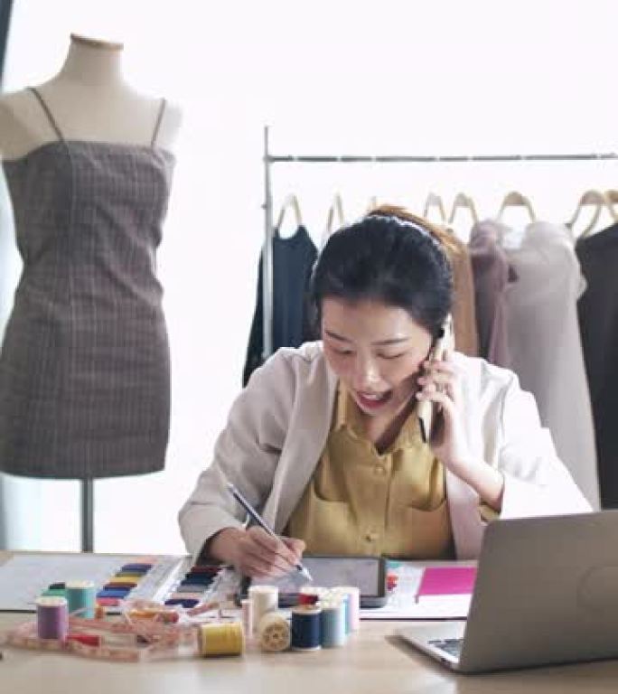 亚洲时装设计师与她的客户通过电话讨论设计师解决方案，垂直