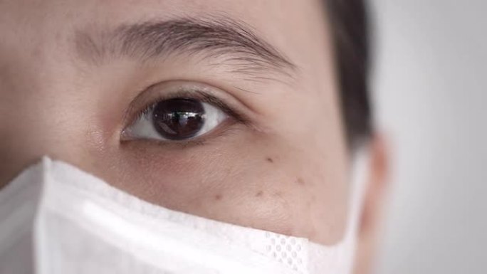 用卫生口罩或医用口罩看着相机的亚洲女性眼睛特写