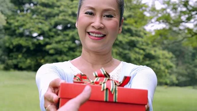 高级女性手握礼品盒，生活方式: 里程碑和庆祝活动