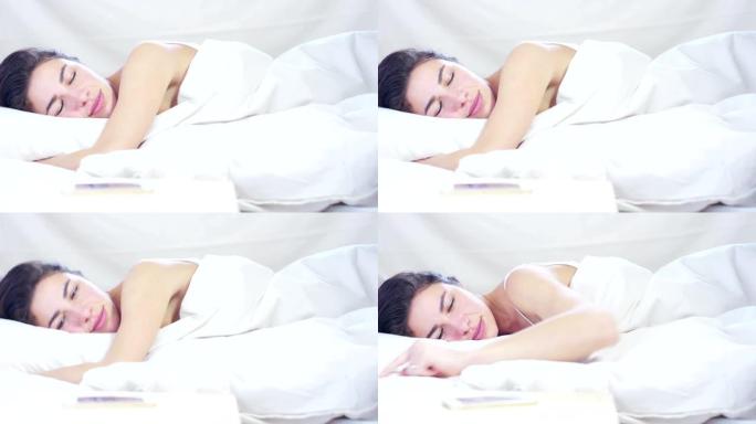 一个美丽的年轻女孩在温暖的床上度过了简单的一天，在白色背景上覆盖着柔软的温暖的白色毯子。