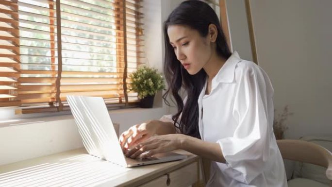 在笔记本电脑上工作的亚洲妇女患有压力和办公室综合症