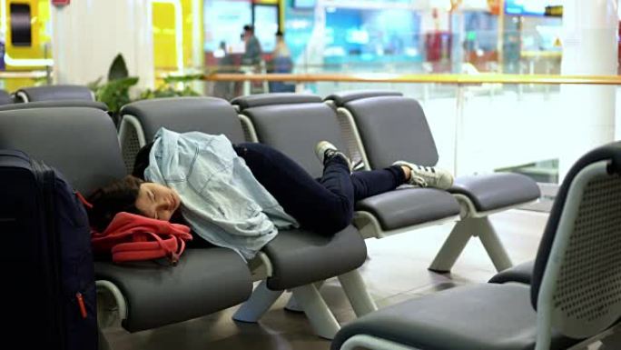 4k镜头有吸引力的亚洲女性旅行者睡觉时带着行李在机场候机楼候机，交通和旅客旅行概念