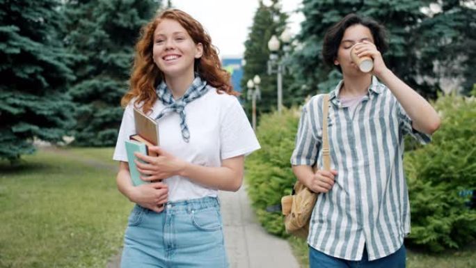 几个青少年在户外散步，拿着书喝咖啡