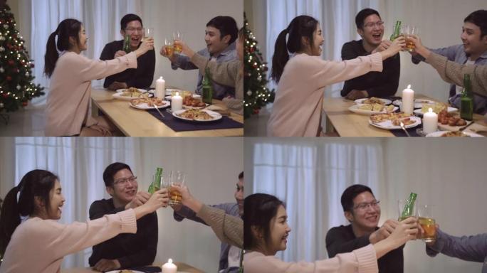 一群亚洲朋友在圣诞晚宴上欢呼雀跃。快乐的泰国人在家里的聚会上一起吃披萨。慢动作场景