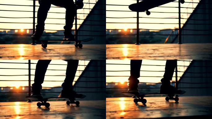 慢动作。剪影滑板手在日落背景上滑板和跳跃。