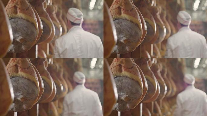 在一家火腿工厂中，一名负责质量控制的人在火腿和控制，香水和经过认证的意大利品质之间行走。