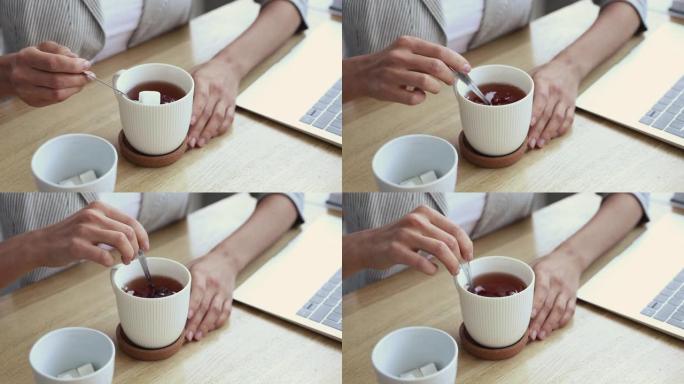 女人在茶中加入方糖，特写镜头