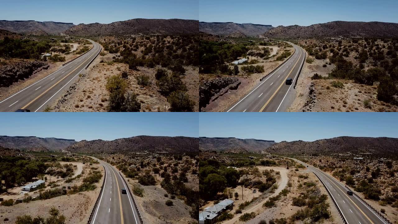 美丽的电影无人机拍摄，银色汽车在美国阳光明媚的沙漠山路上行驶。公路旅行冒险假期。