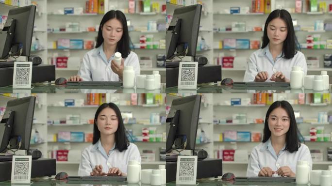一个年轻的亚洲药剂师女人在药店微笑着看着相机的特写肖像。