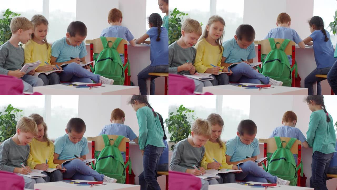 一群小孩子在休息时在工作簿上写作