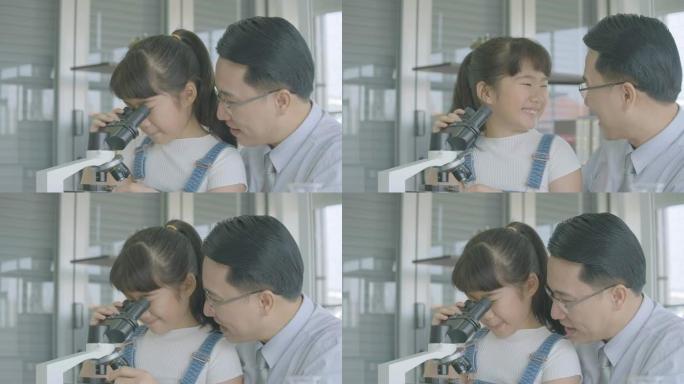 亚洲男科学家在教室实验室用显微镜教小女孩科学实验。有科教理念的人。