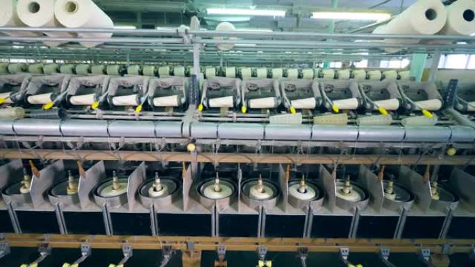 工厂机器正在用螺纹卷筒。服装厂生产设备。