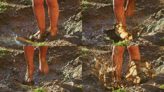 赤脚小女孩无忧无虑的真实镜头特写在泥泞的水坑里玩耍和跳跃