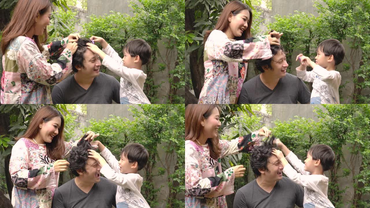 幸福的家庭年轻的亚洲妇女和她的儿子试图在家里用剪刀为她的丈夫理发，因为封锁。居家隔离冠状病毒大流行预