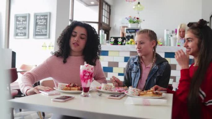 十几岁的女孩一起在餐厅吃甜点