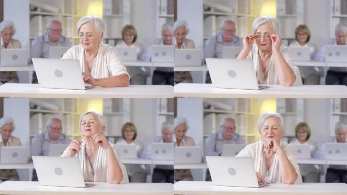 在计算机课上摆姿势的老年妇女