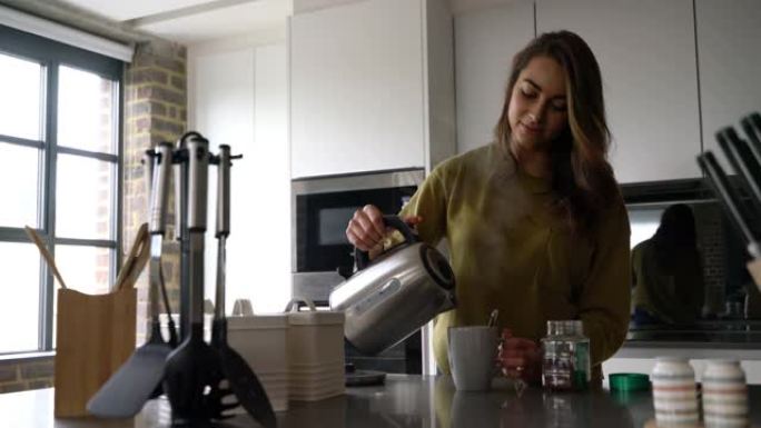 年轻女子在家为自己煮咖啡，用杯子里的热水