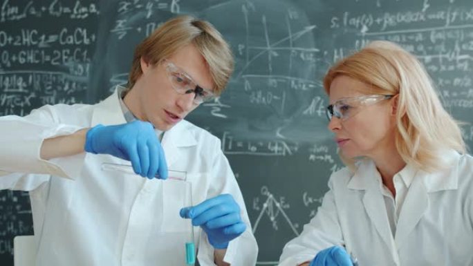 男女化学家在实验室工作，试管忙于实验