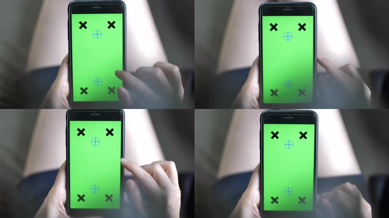 使用绿屏智能手机的特写女性