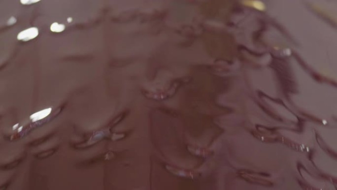 在巧克力背景下，一家专业工厂的机器可以防止美味的棕色巧克力制作糖果。