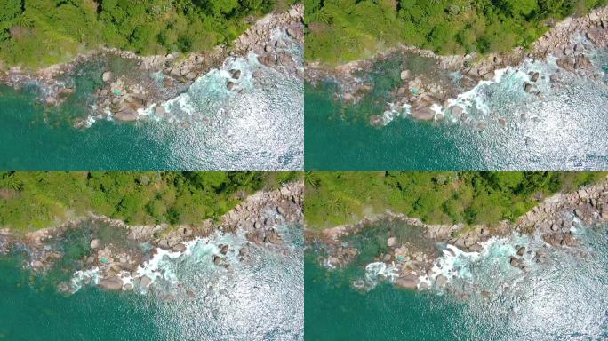 俯视图移开海洋蓝浪冲撞海岸线悬崖。慢动作中的空中4k镜头