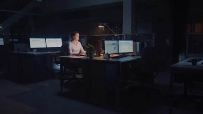 在办公室工作到深夜: 女商人使用台式计算机，分析，使用文档，解决问题，完成重要项目。勤奋有抱负的青年
